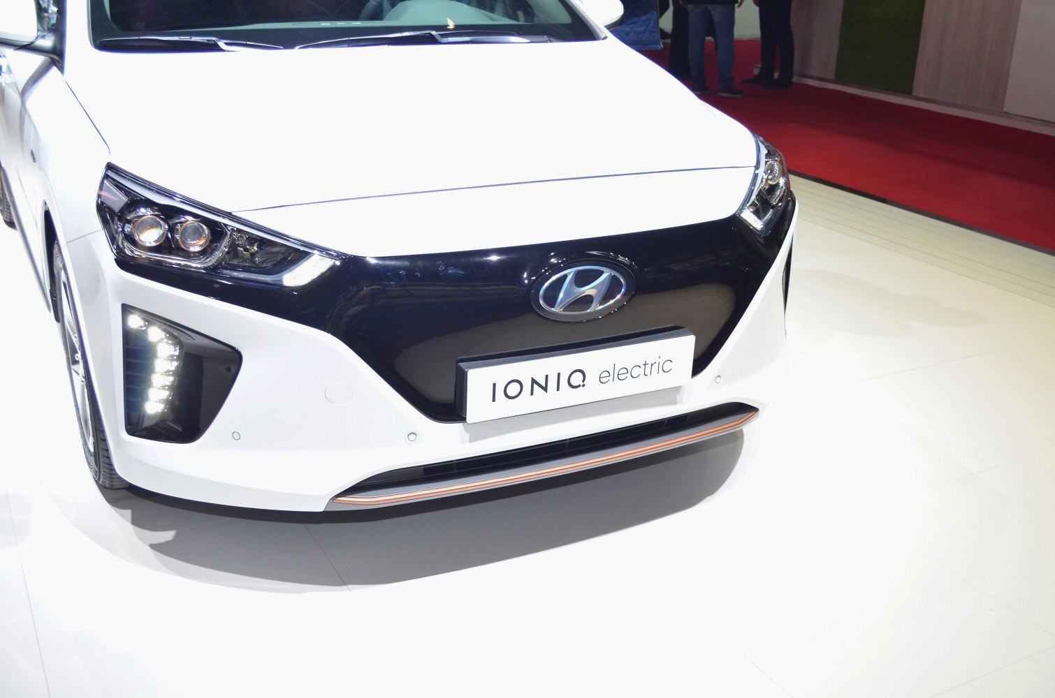Modern electric car front with LED headlights and distinct black grille