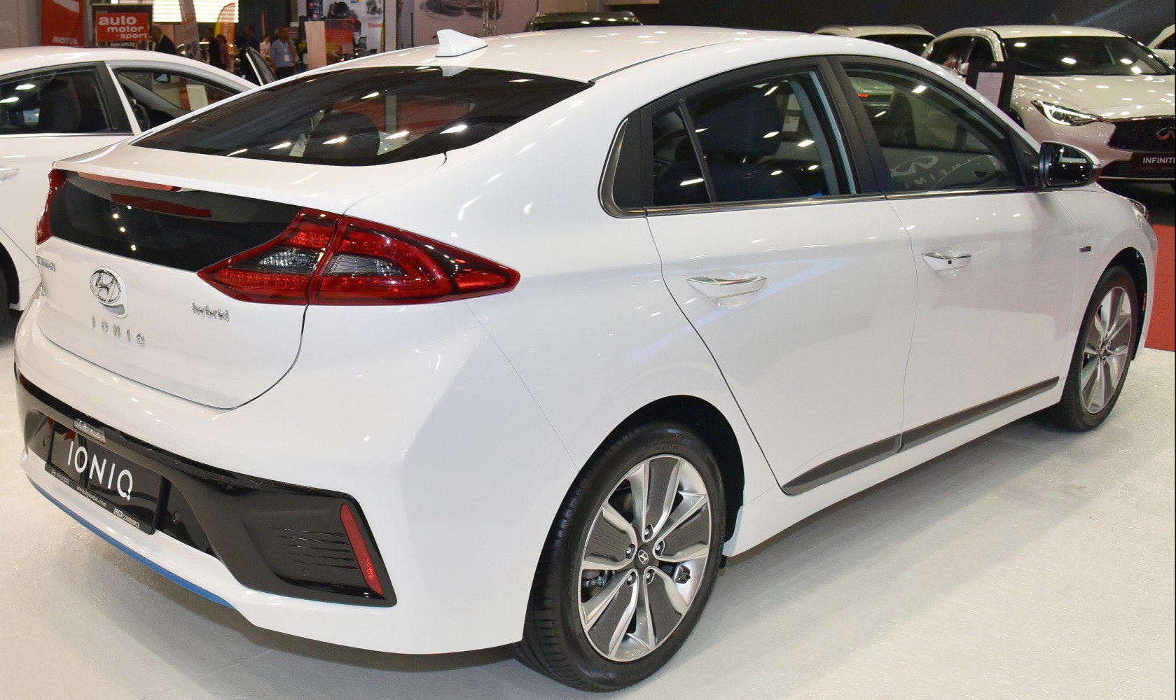 Rear side view of white hatchback hybrid with alloy wheels