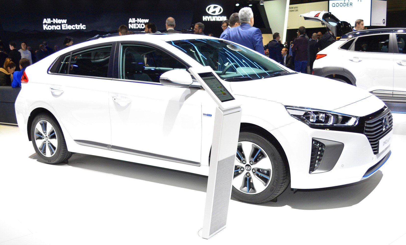 Side and front view of a white electric sedan with aerodynamic shape and unique wheels