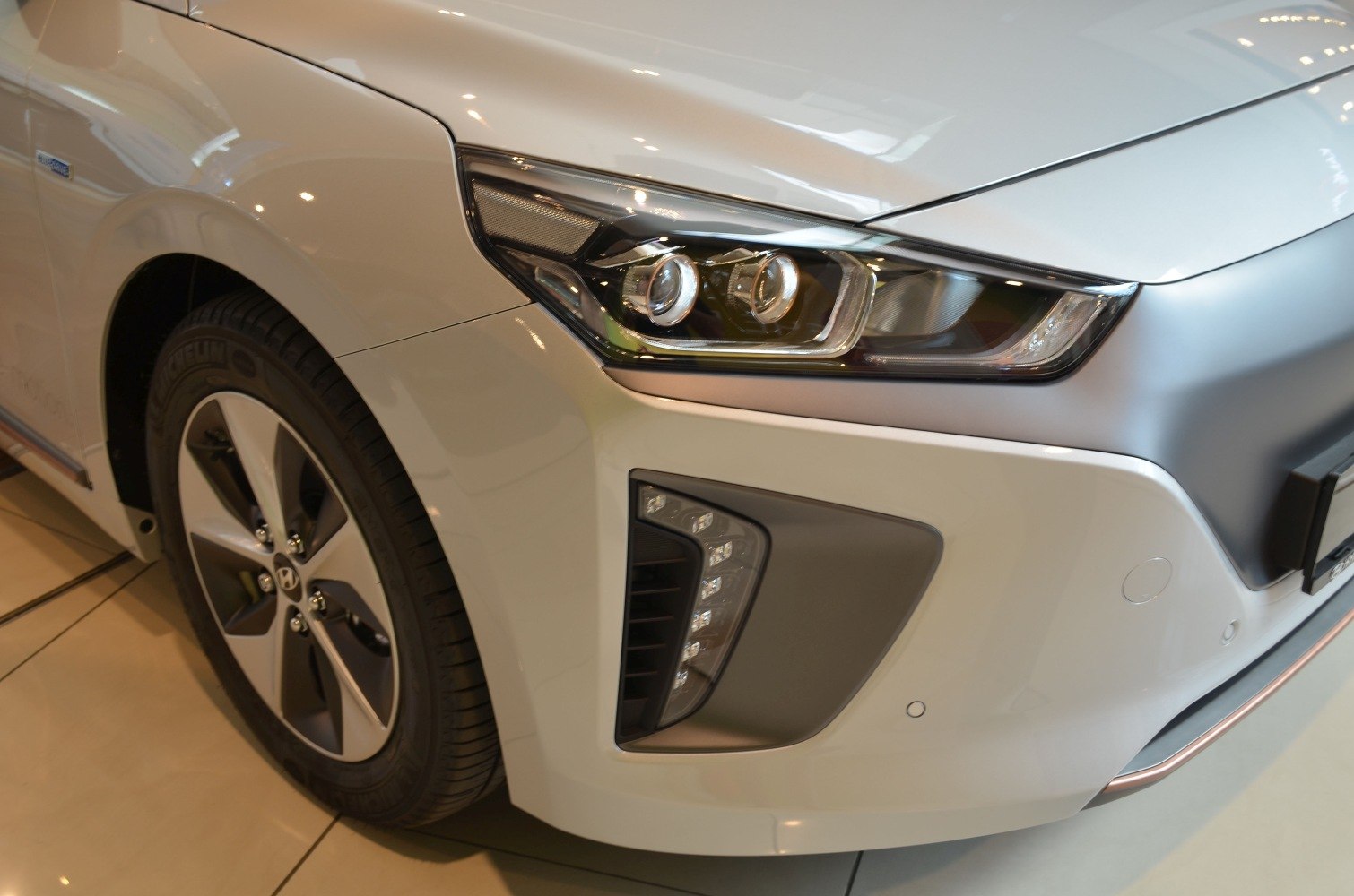 Close-up of front LED headlight and alloy wheel design