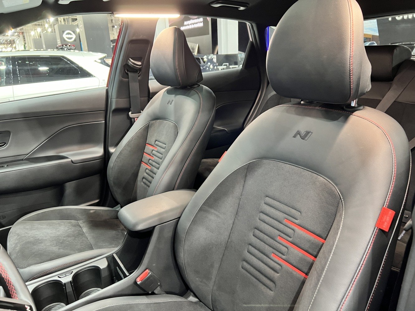Black leather car seats with red stitching and embossed 'N' logo