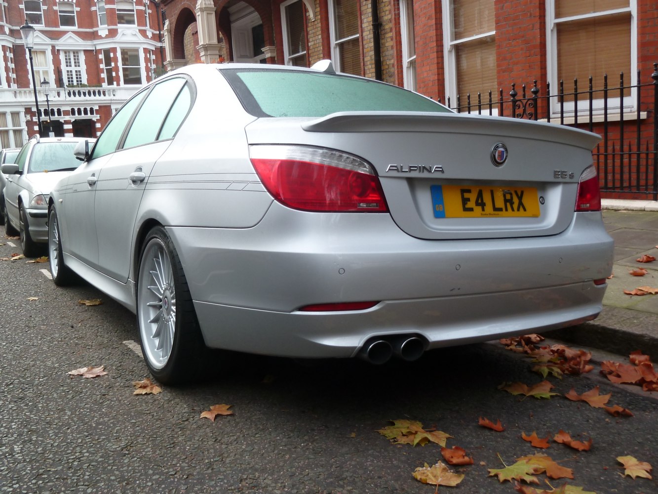 Rear view of a silver sedan with quad exhaust and rear spoiler