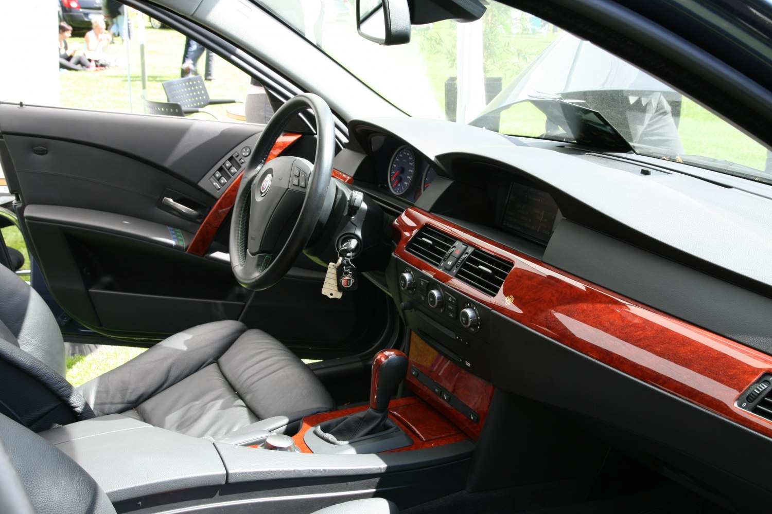 Leather seats and wood trim dashboard with steering wheel and gear shift