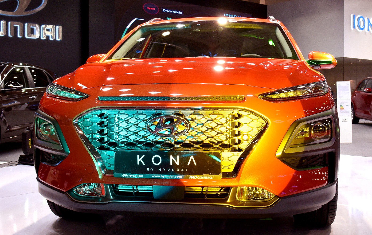 Orange Kona SUV front with distinctive grille and sleek headlights