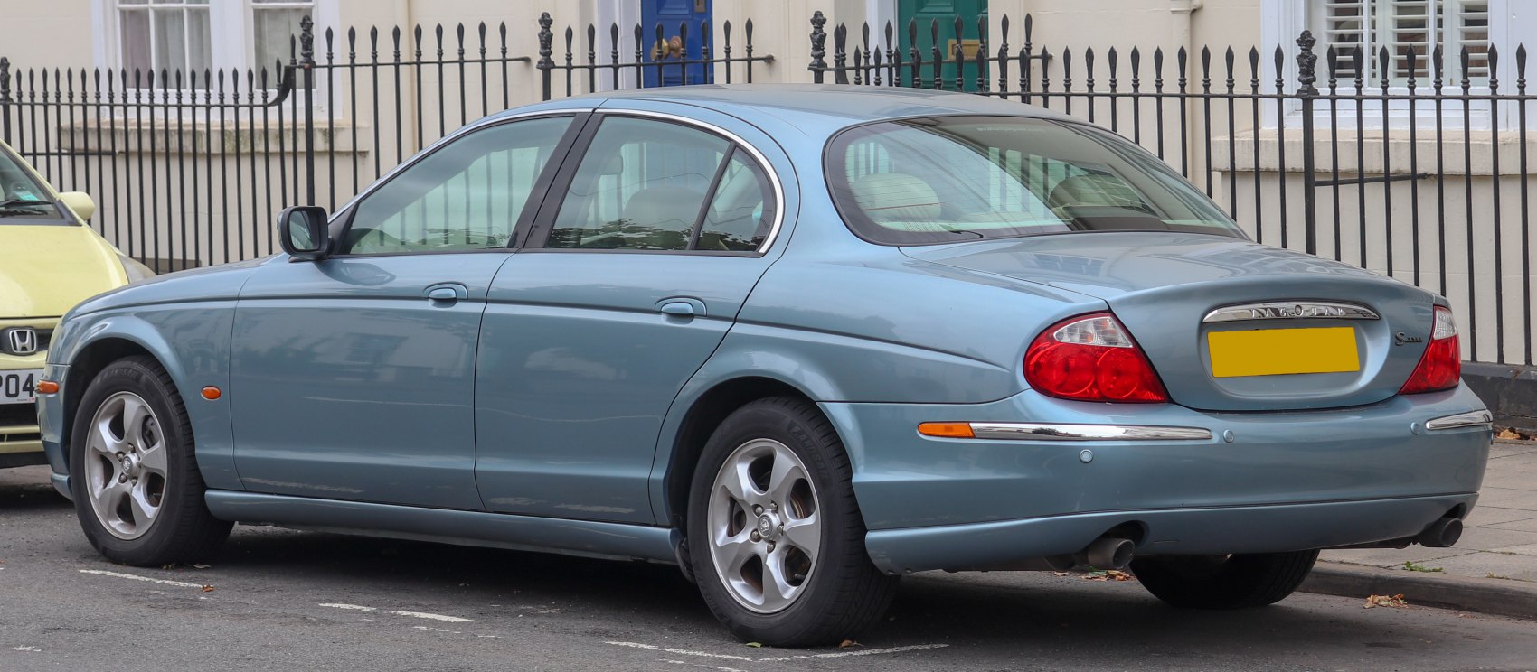 Rear side profile of a classic luxury sedan with alloy wheels and chrome detailing.