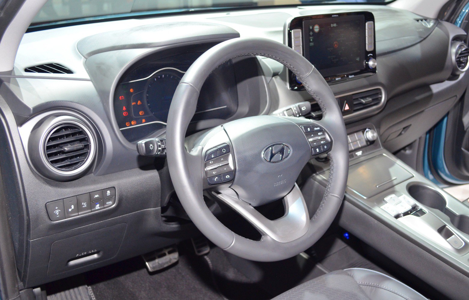 Steering wheel with control buttons and digital dashboard with infotainment display