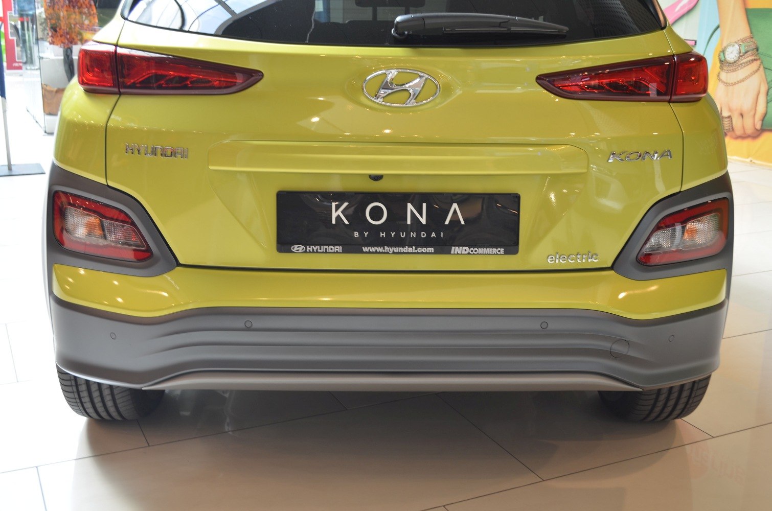 Rear end view with taillights and bumper of a yellow electric vehicle