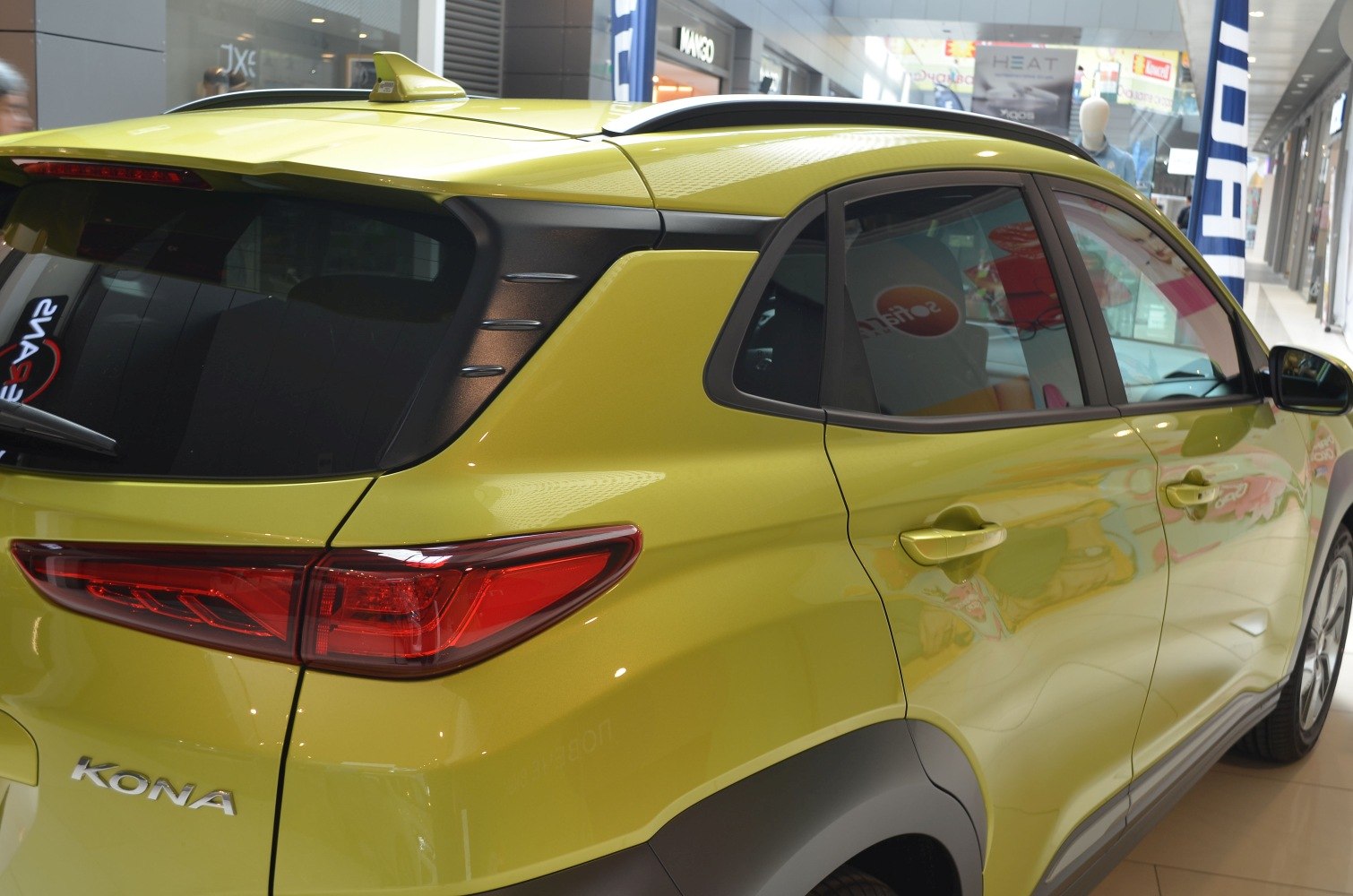 Rear and side view featuring sharp taillights and unique rear window trim.