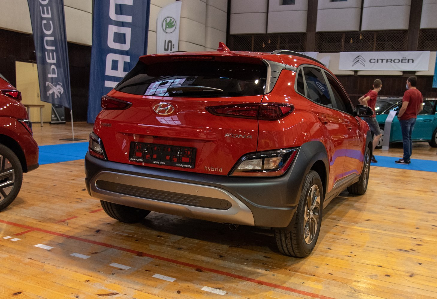 Red compact hybrid SUV rear with narrow LED tail lights and sculpted bumper