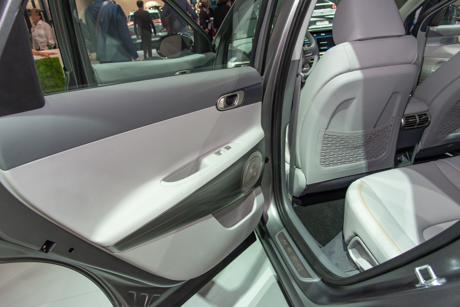 Rear door panel and backseat interior with speaker and net storage details.