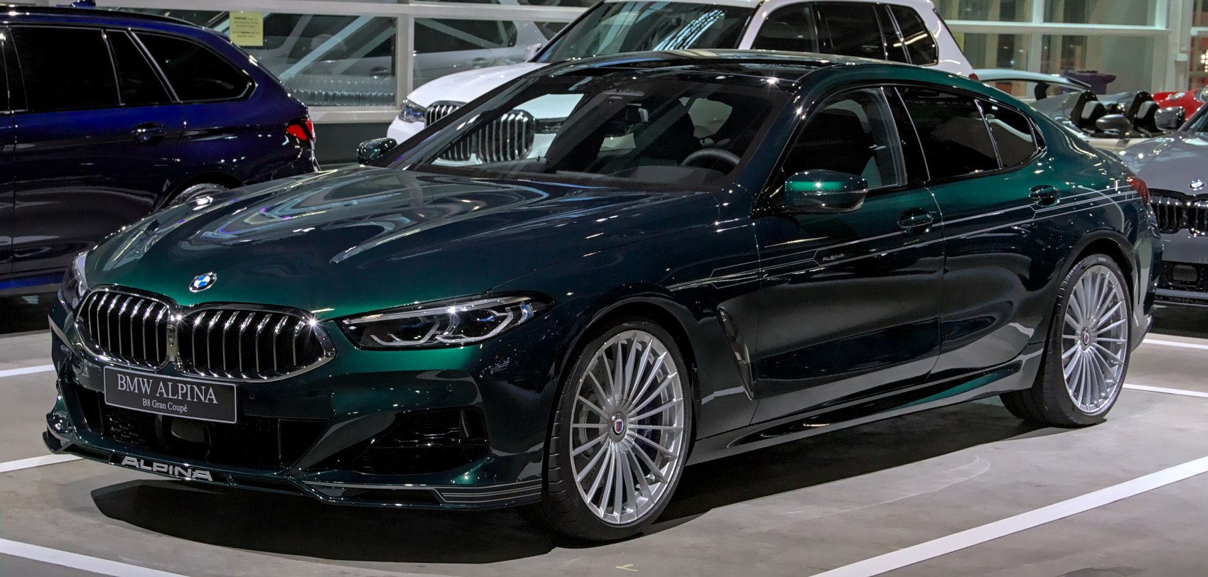 Luxury four-door coupe with Alpina multi-spoke wheels and distinctive front grille.