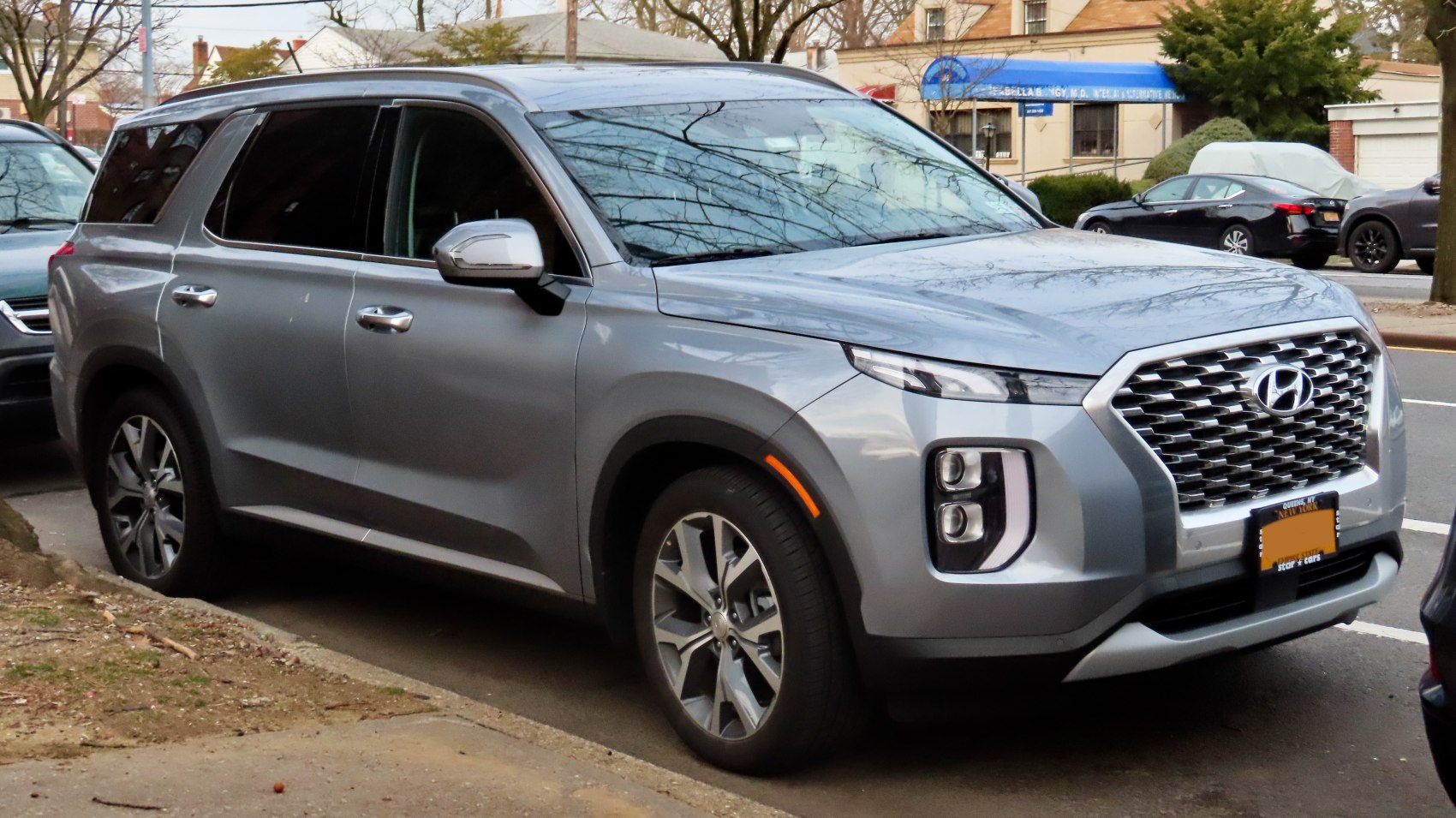 Modern SUV with stacked headlights and large hexagonal grille.