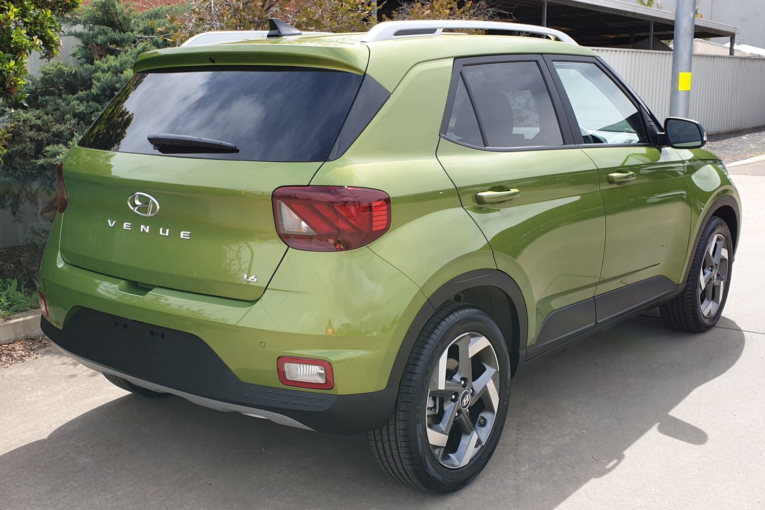 Rear and side view with taillights, alloy wheels, roof rails.