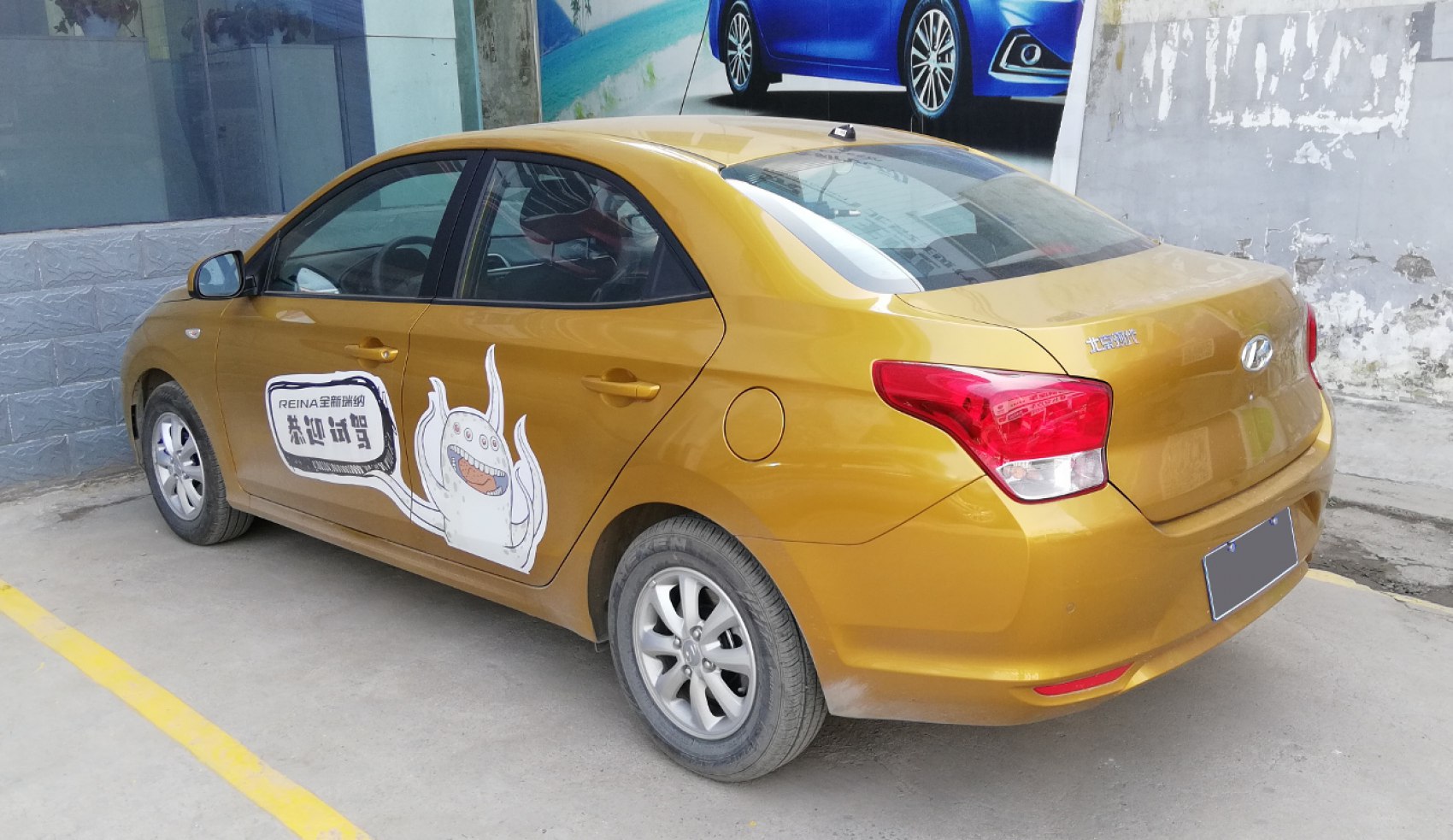 Rear side view of a compact sedan with promotional decal