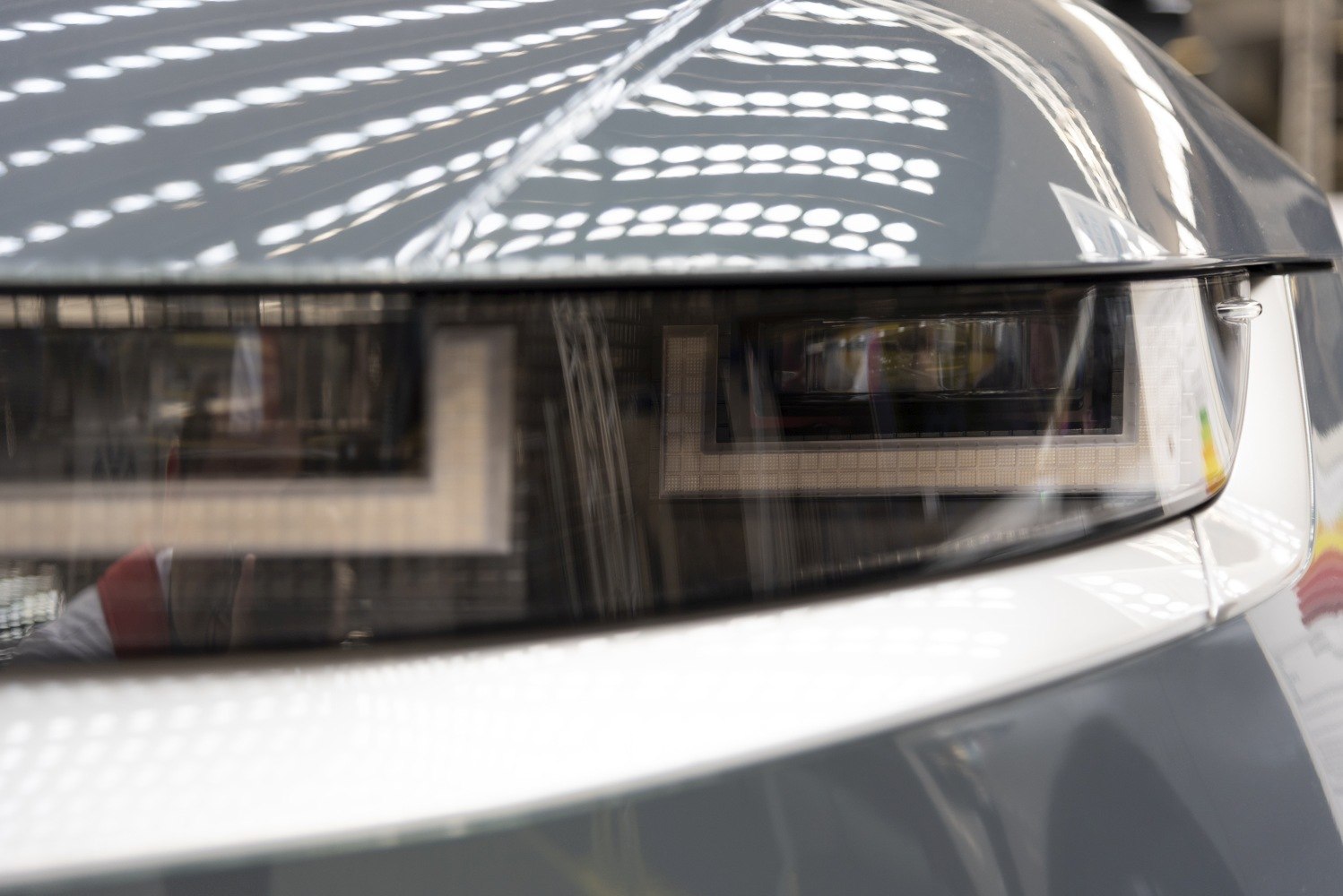 Close-up of angular LED headlight design with futuristic styling.
