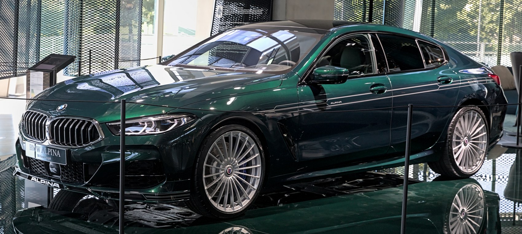 Front side view of a luxury sedan with detailed headlights and multi-spoke wheels.