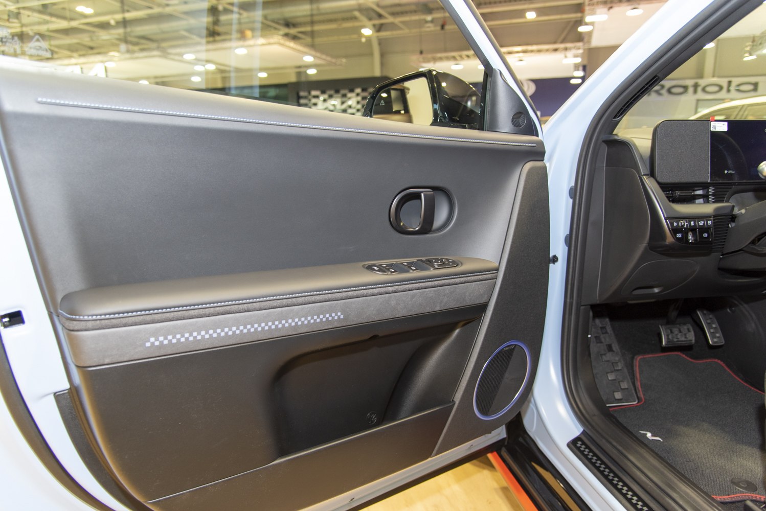 Interior door panel with window controls, door handle, and speaker
