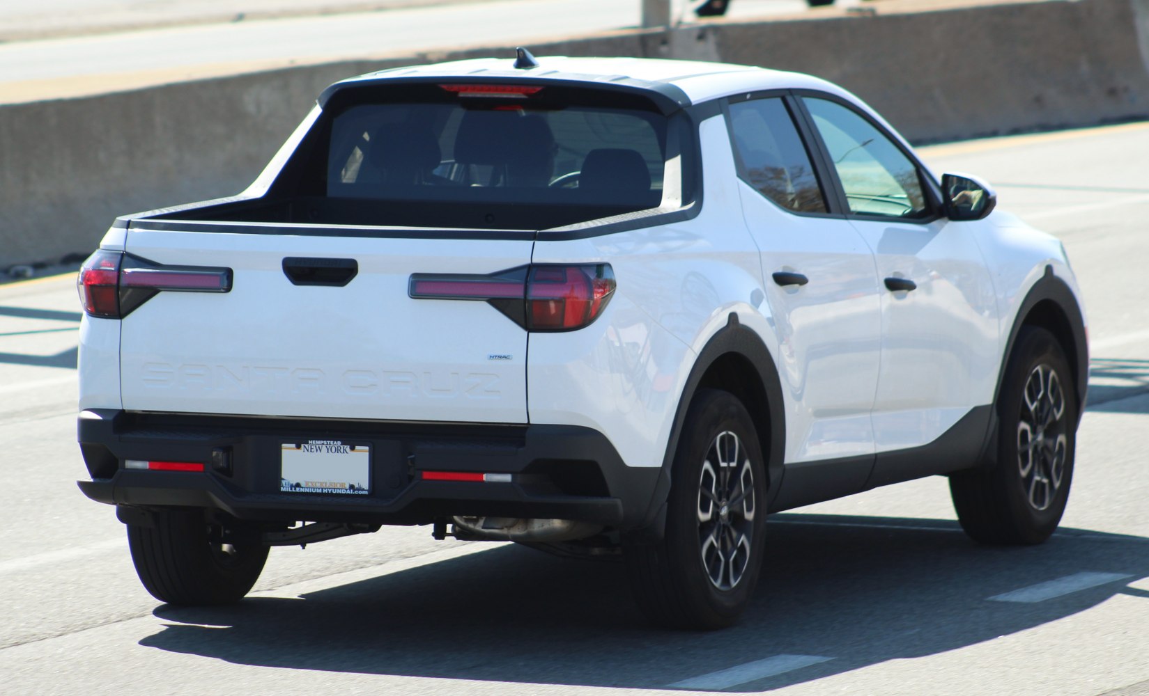 Rear and side view of a modern pickup truck with distinctive tailgate and wheel design