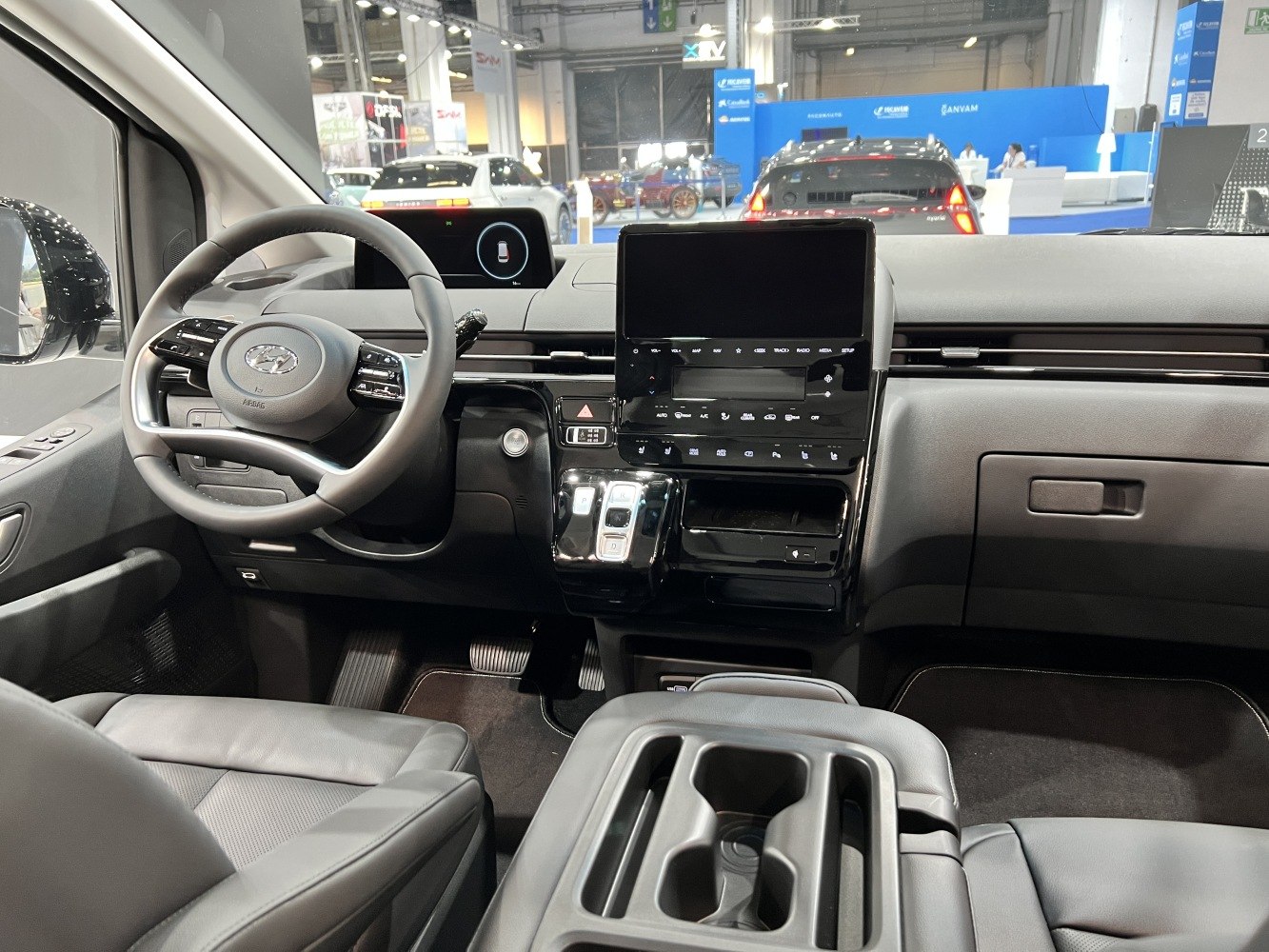 Modern vehicle dashboard and multifunction steering wheel with digital displays.