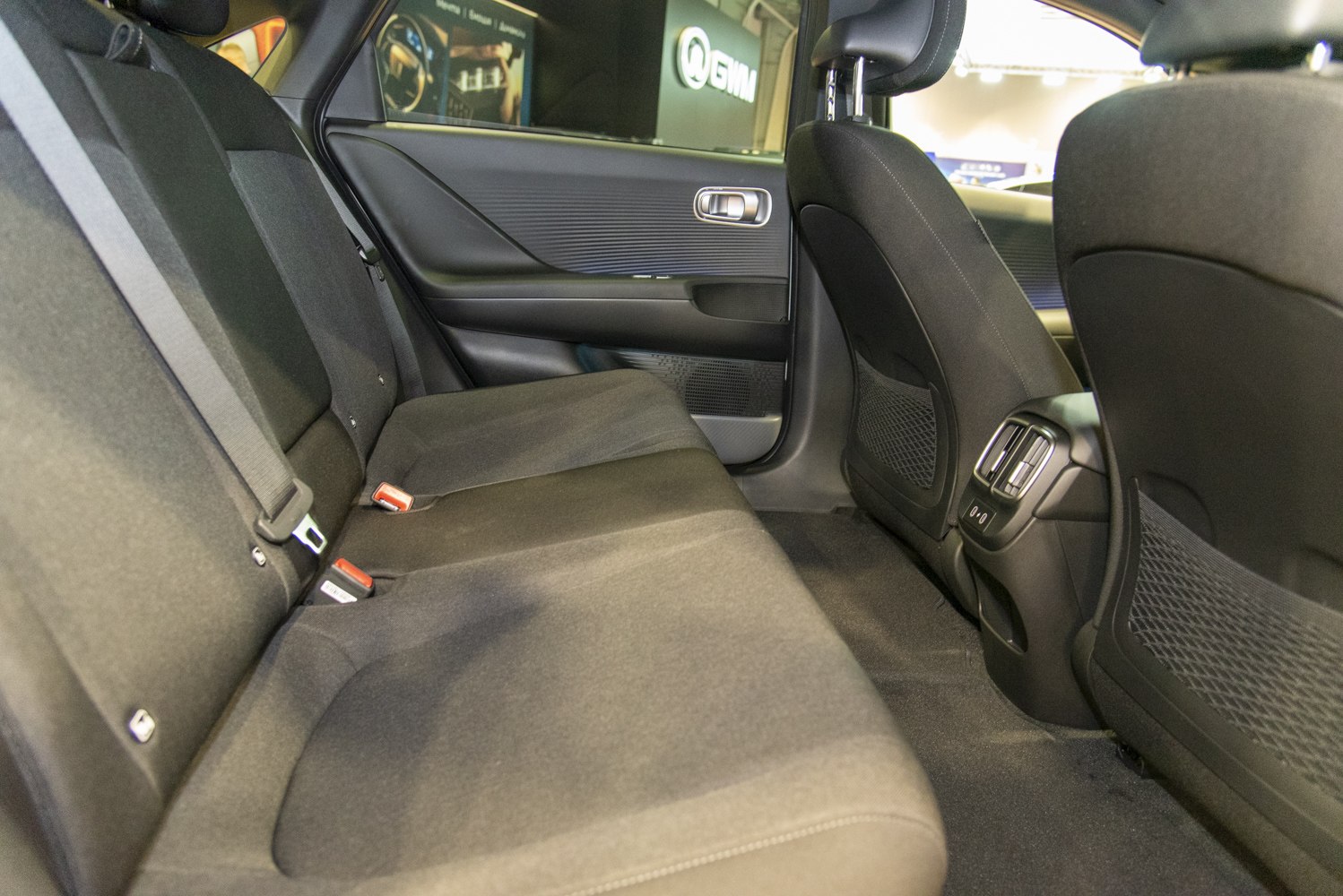 Rear seat interior with cloth upholstery, air vents, and USB ports