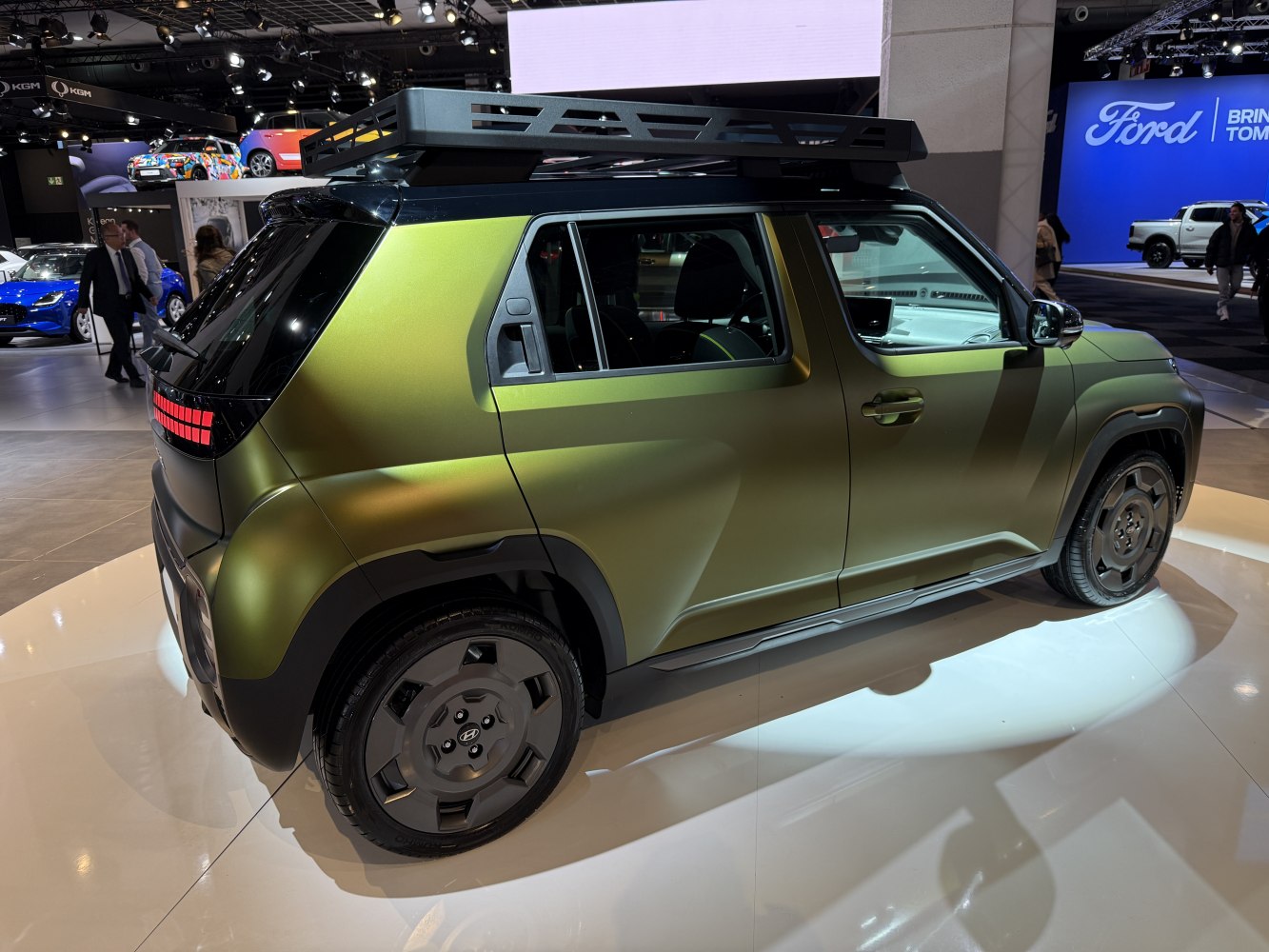 Matte green compact SUV with roof rack and tinted windows