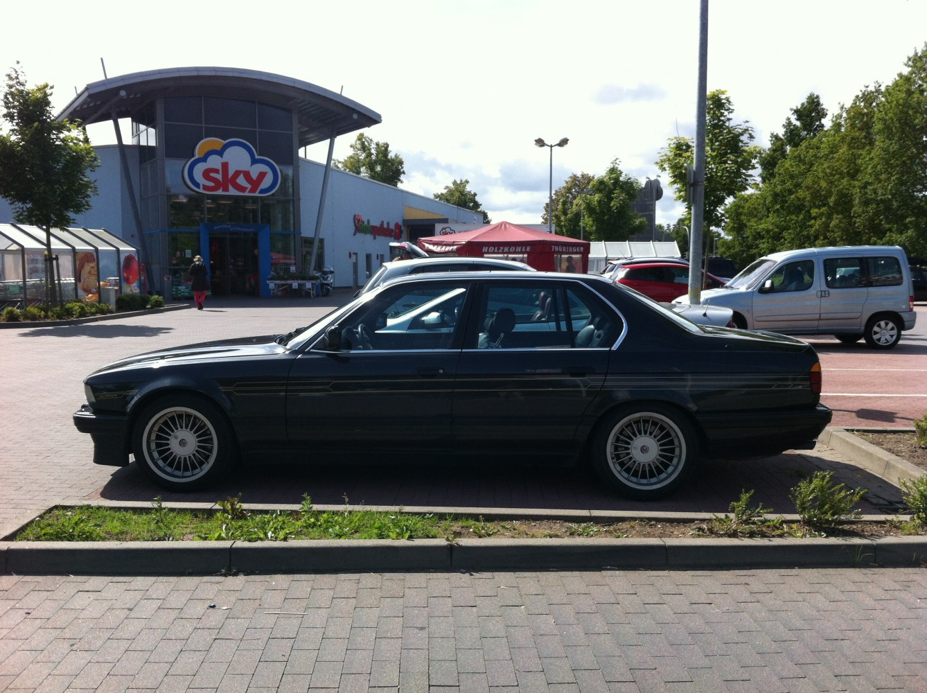 Classic four-door sedan with multi-spoke wheels and side decals