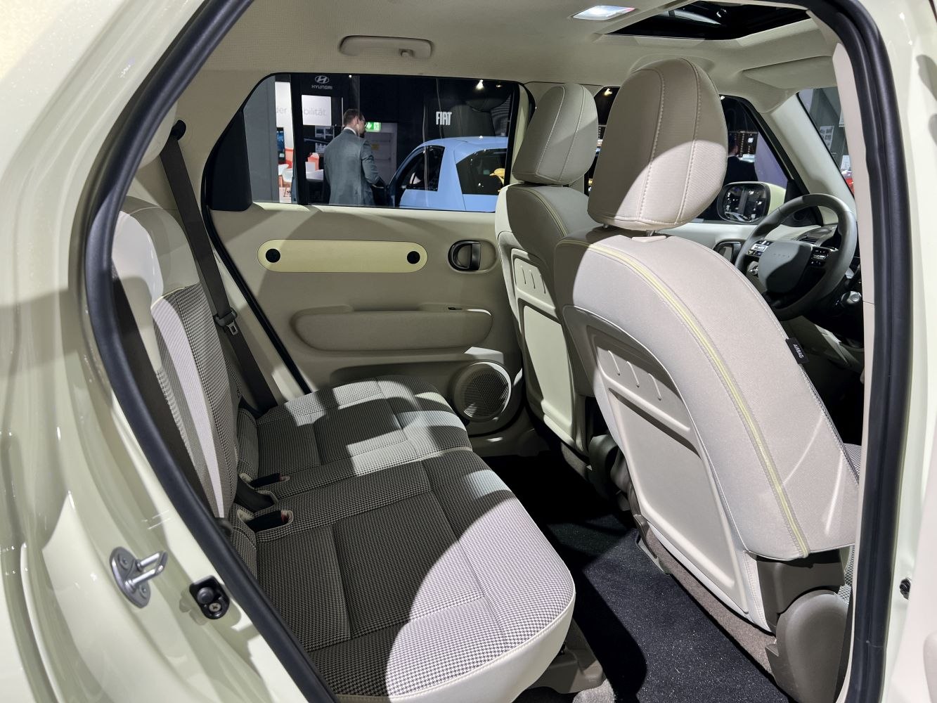 Rear seat and door panel with beige fabric upholstery
