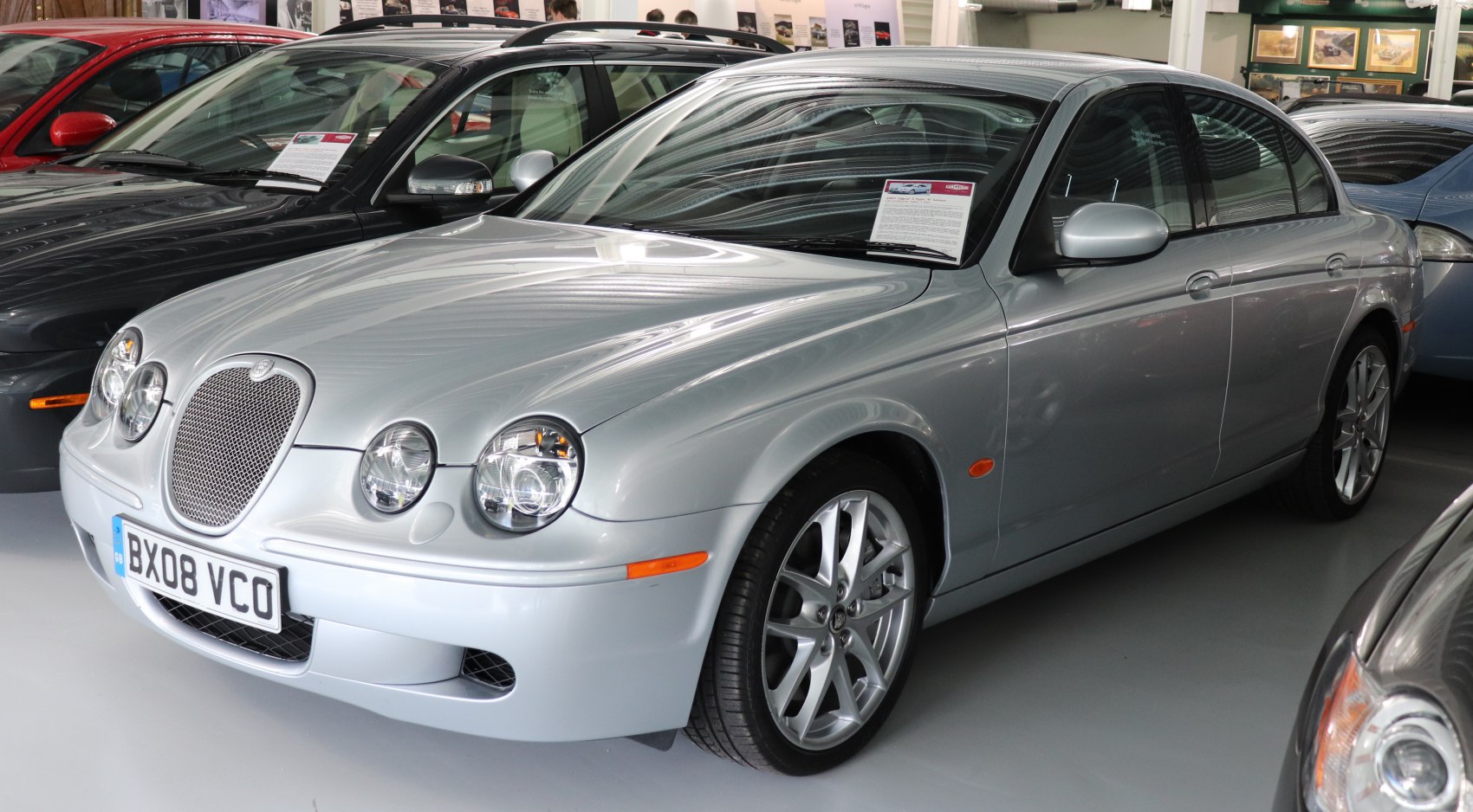 Silver sedan with quad round headlights and mesh grille front