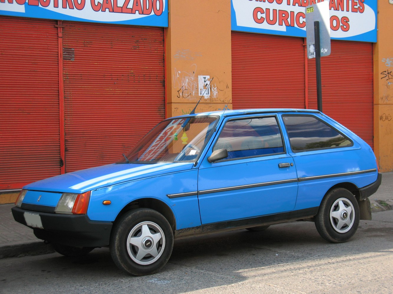 Blue classic hatchback showing side profile with angular design.