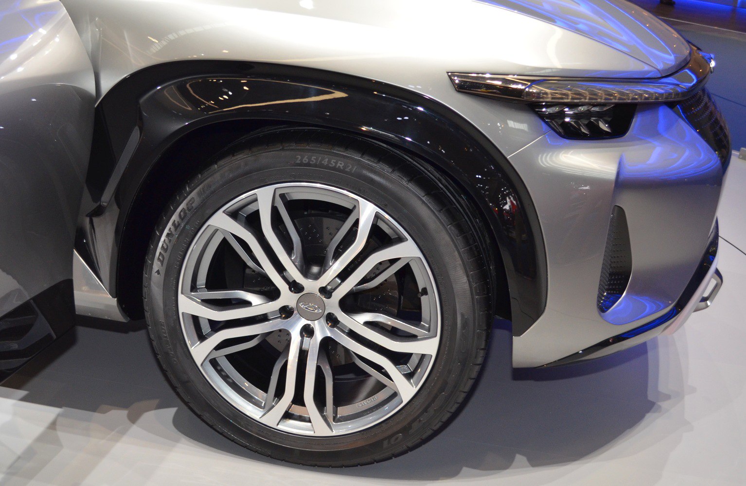 Close-up of front wheel with alloy rim and modern LED headlight.