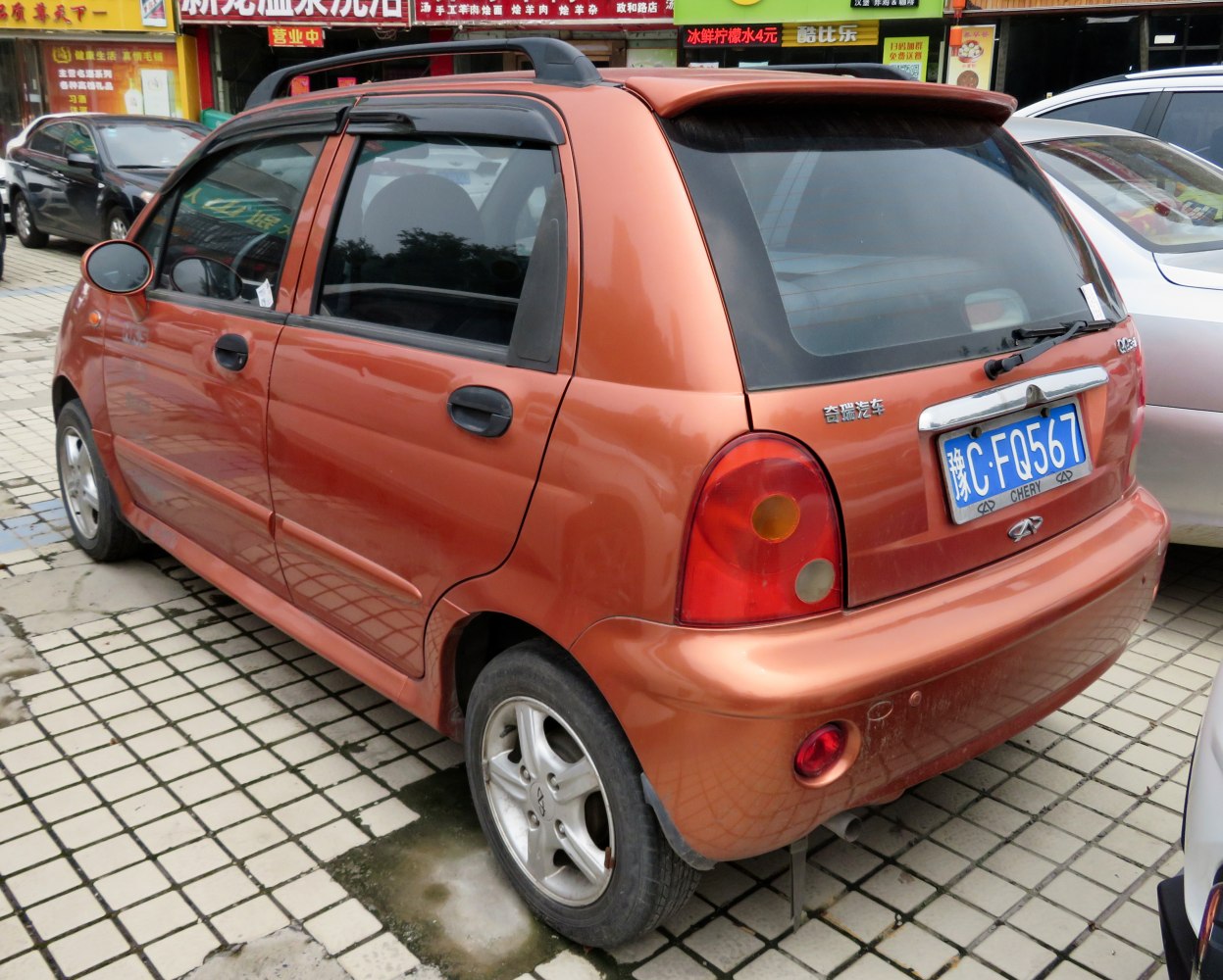 Rear side view of compact hatchback with spoiler and alloy wheels