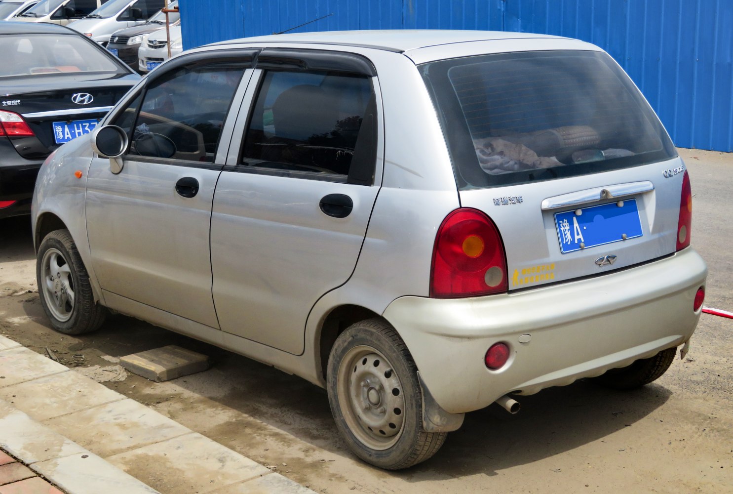 Compact hatchback rear with round tail lights and tinted windows