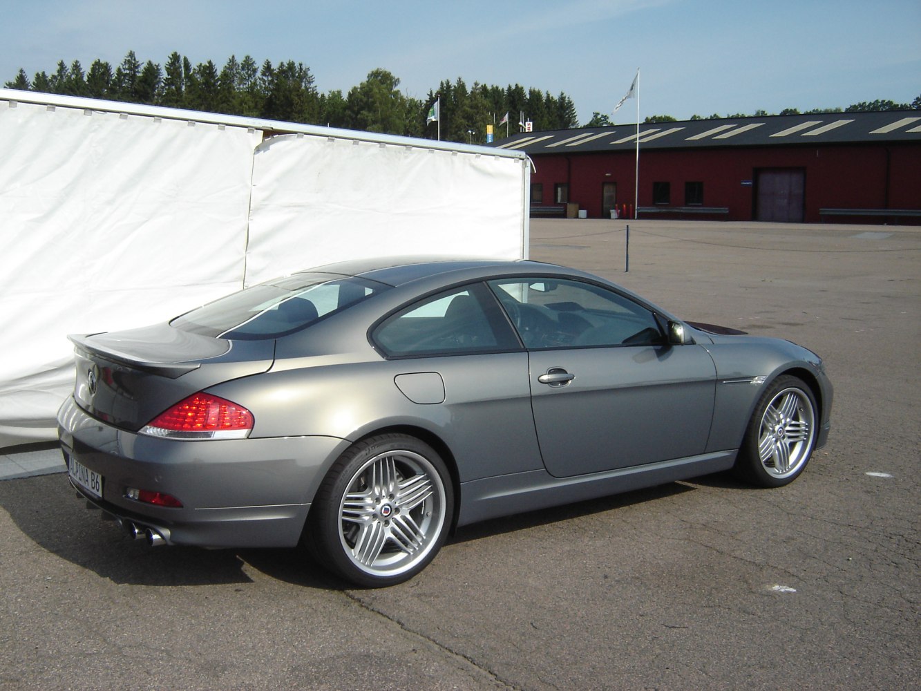 Rear-side view of coupe with quad exhaust and alloy wheels