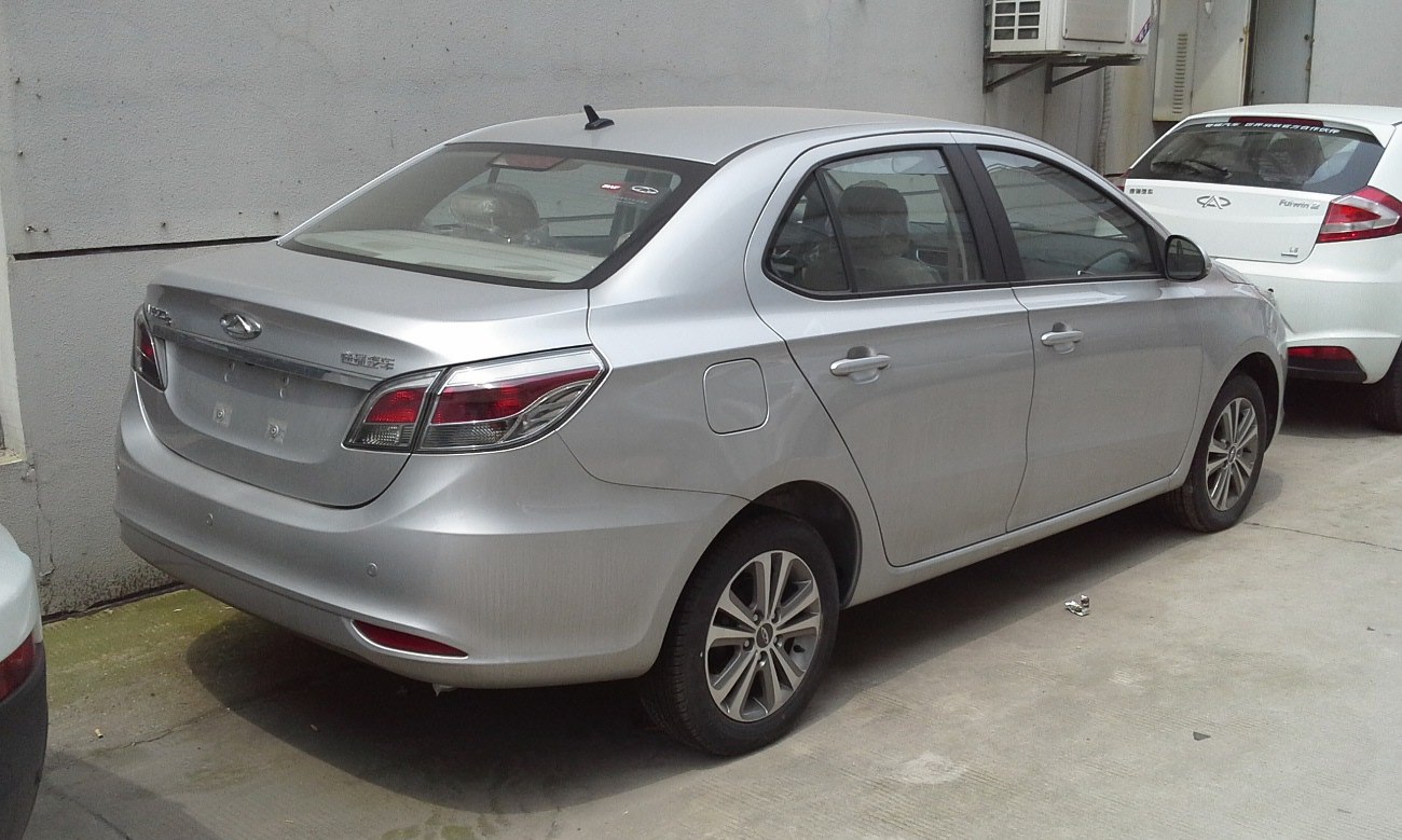 Silver sedan with rear light cluster and alloy wheels from rear-side angle