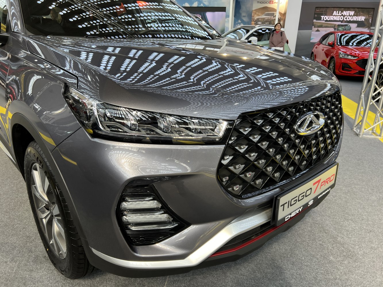 Close-up of front grille and headlight with geometric patterns and modern lighting