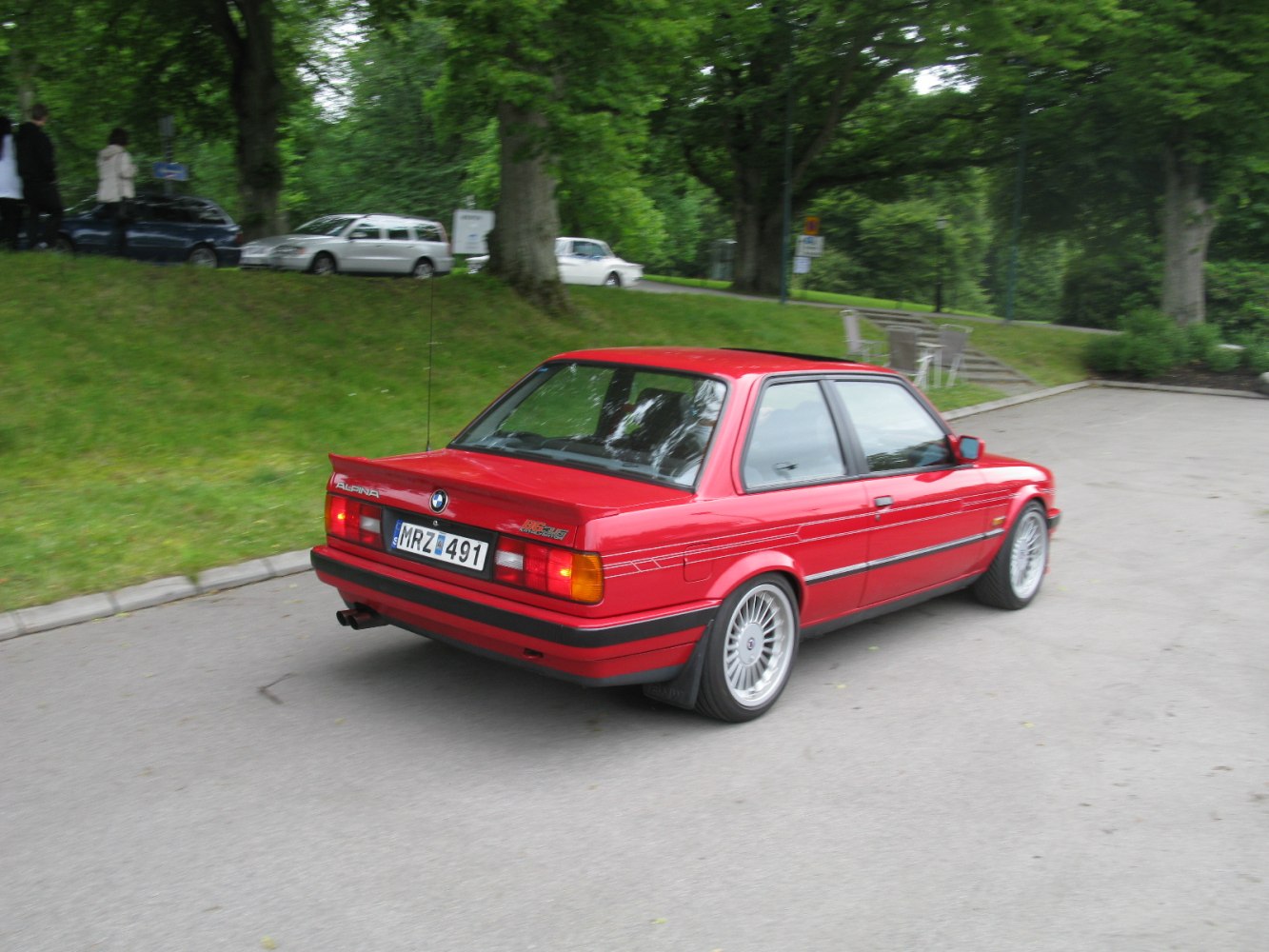 Red vintage coupe with rear spoiler and multi-spoke wheels