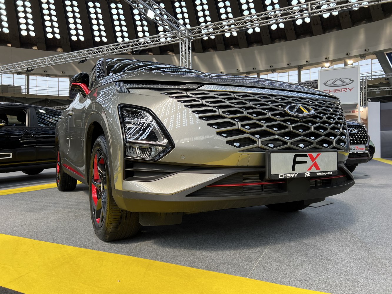 Hexagonal grille with integrated LED headlights and red-accented rims