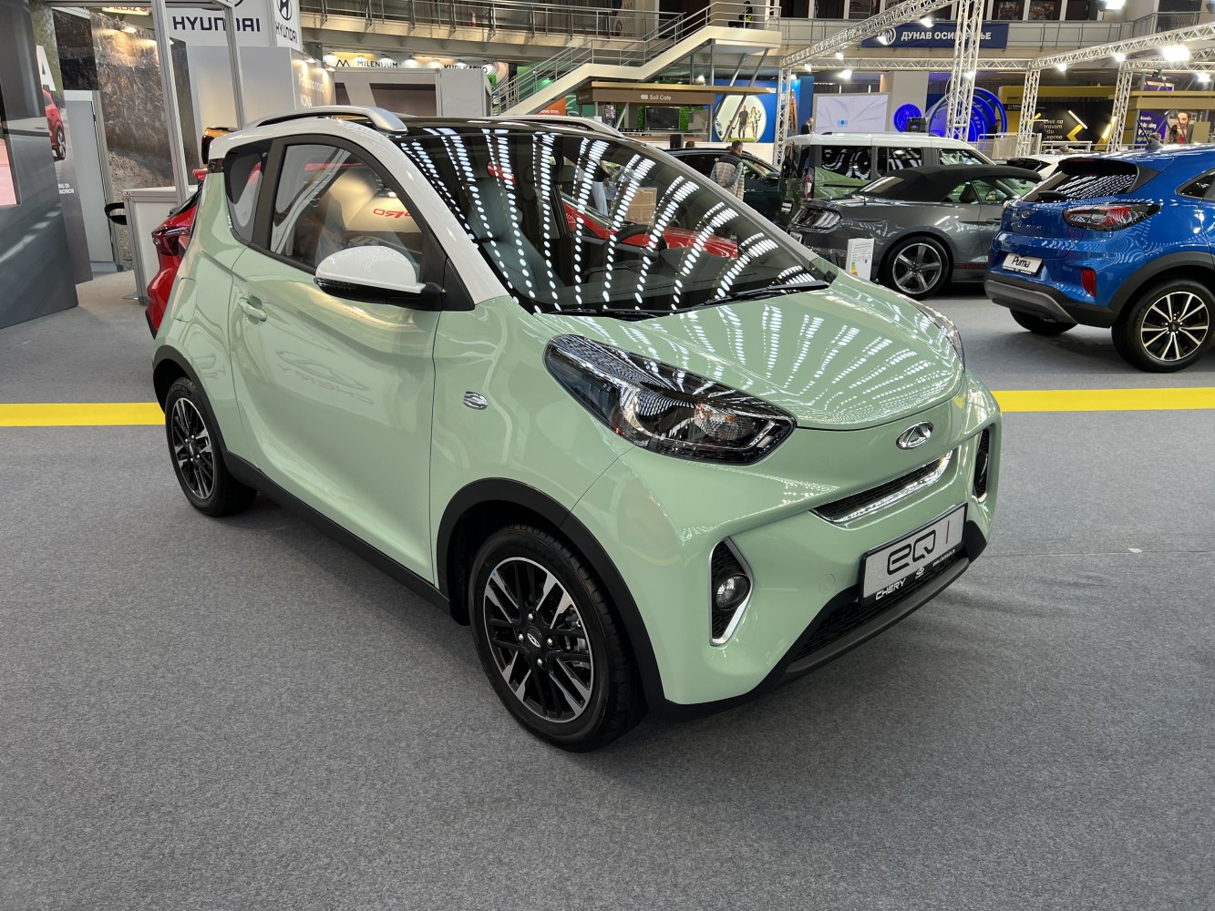 Compact electric car front and side with modern headlights and sporty wheels