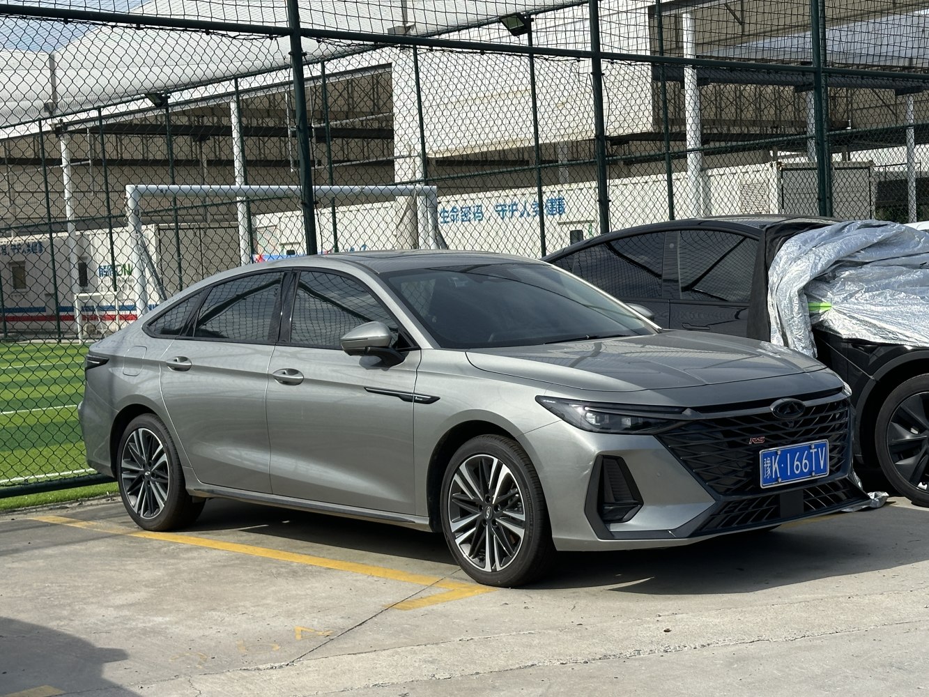 Front side exterior view of a modern sedan with sharp headlights and dynamic grille
