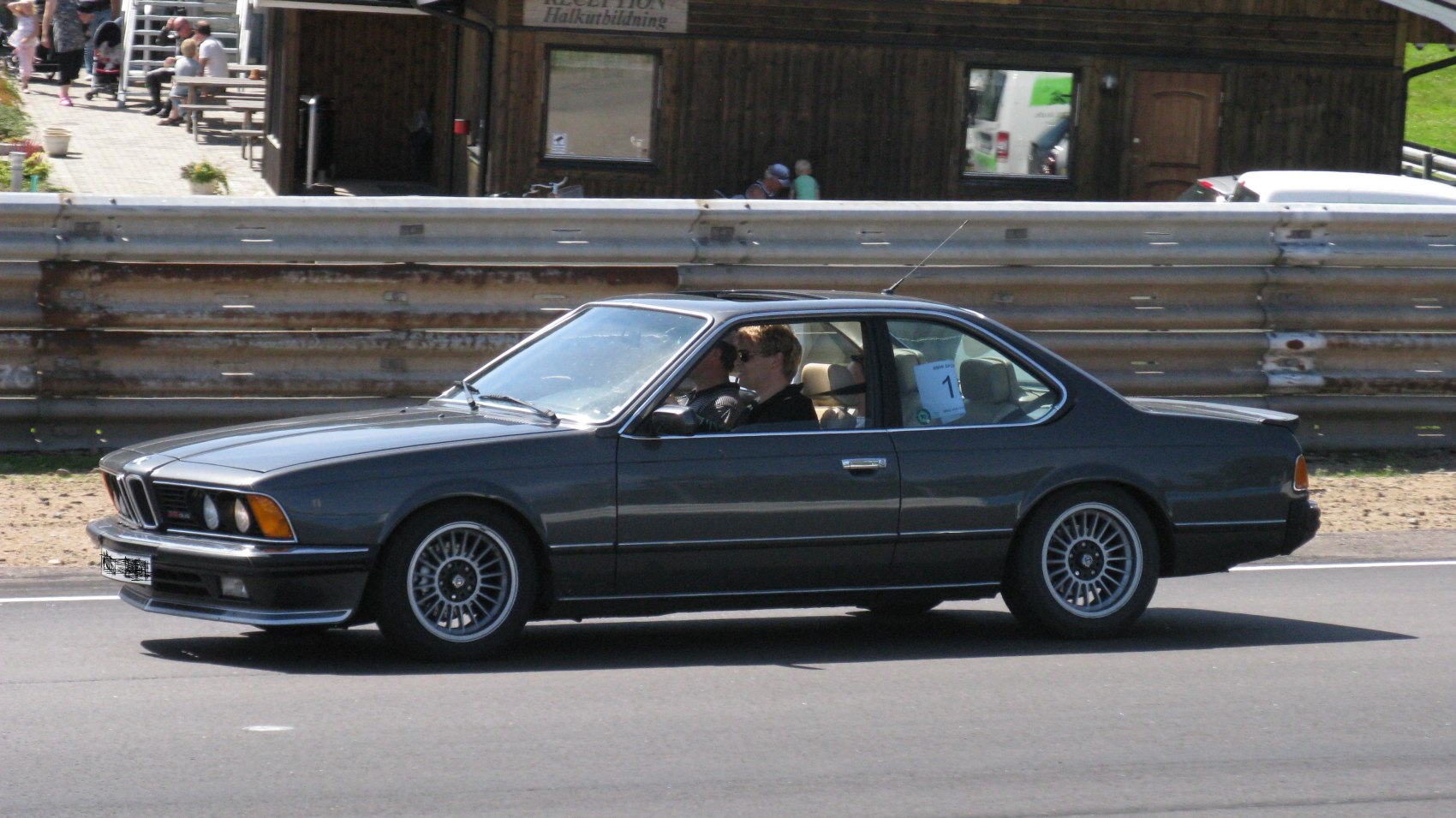 Side profile of sports coupe with multi-spoke wheels and sunroof