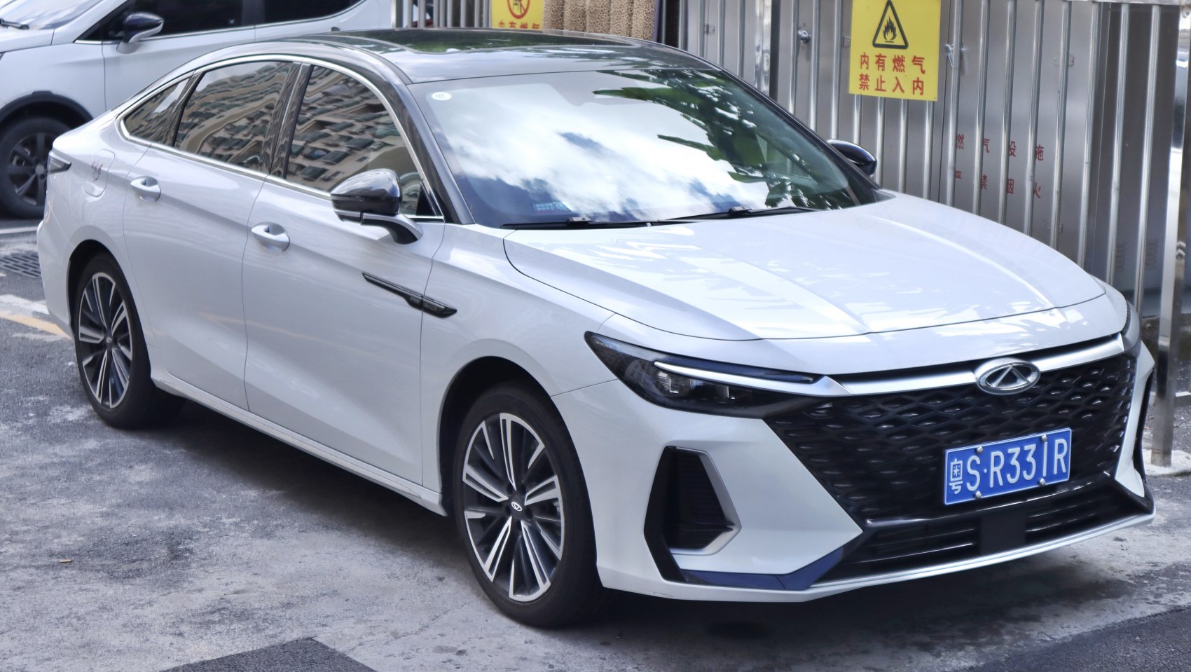 Front side view of a modern sedan with sleek headlights and black roof