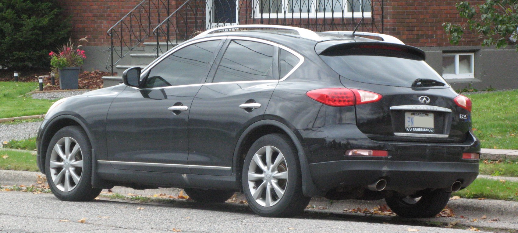 Rear and side view of SUV with tinted windows, alloy wheels, and dual exhaust setup