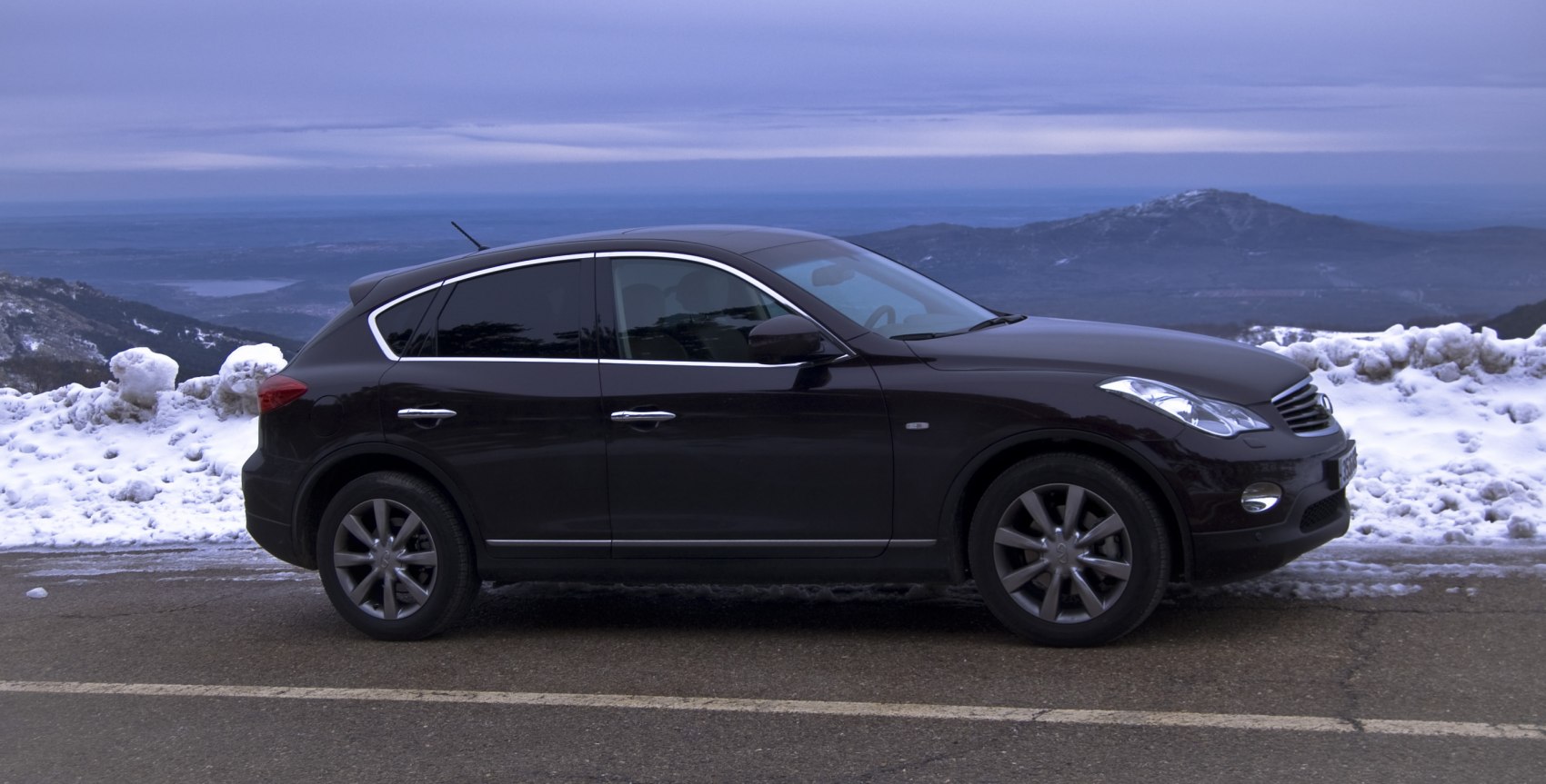 Side profile of a sleek SUV with alloy wheels and curved roofline.