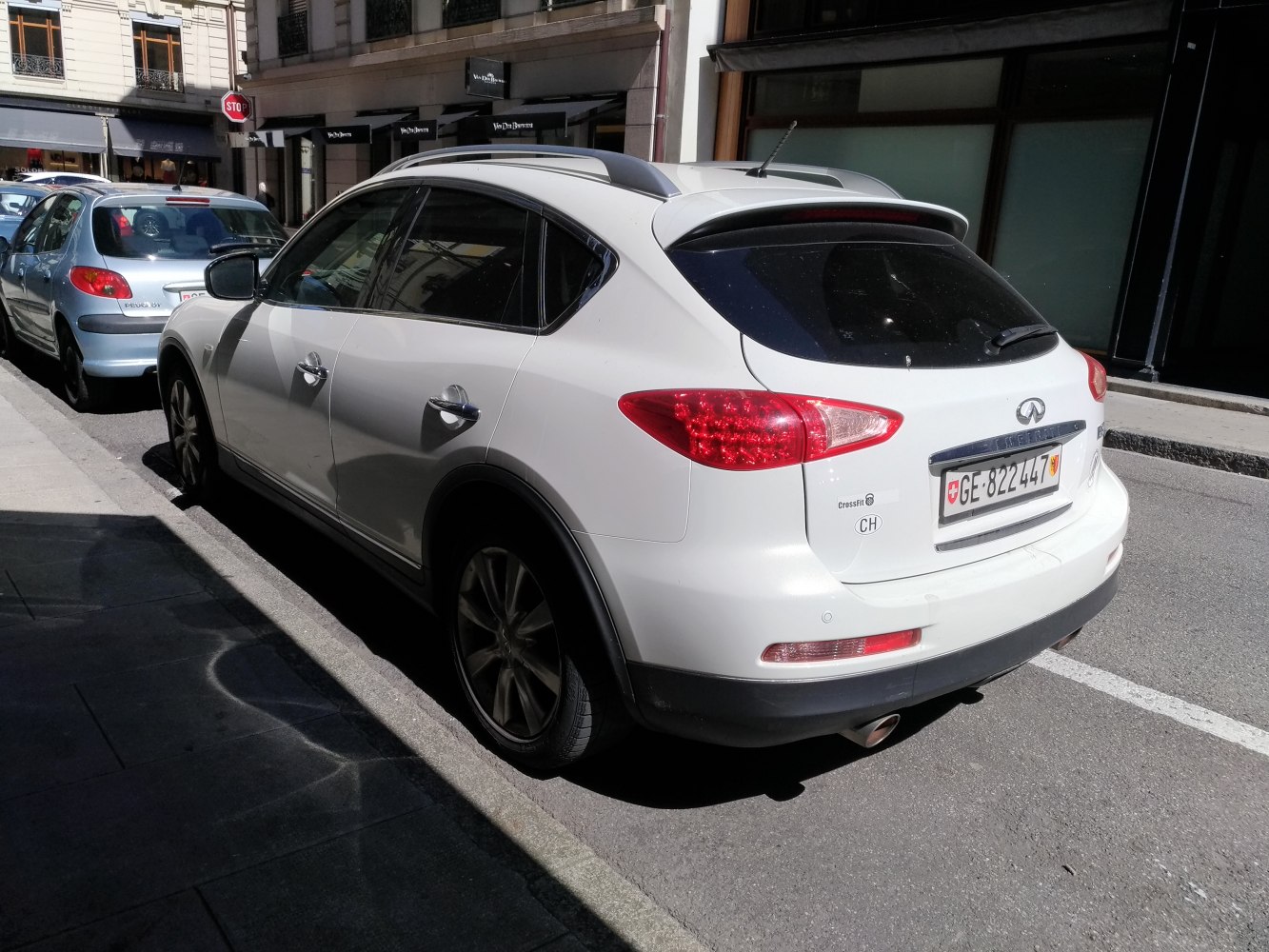 Rear view of white SUV with roof rails and rear spoiler