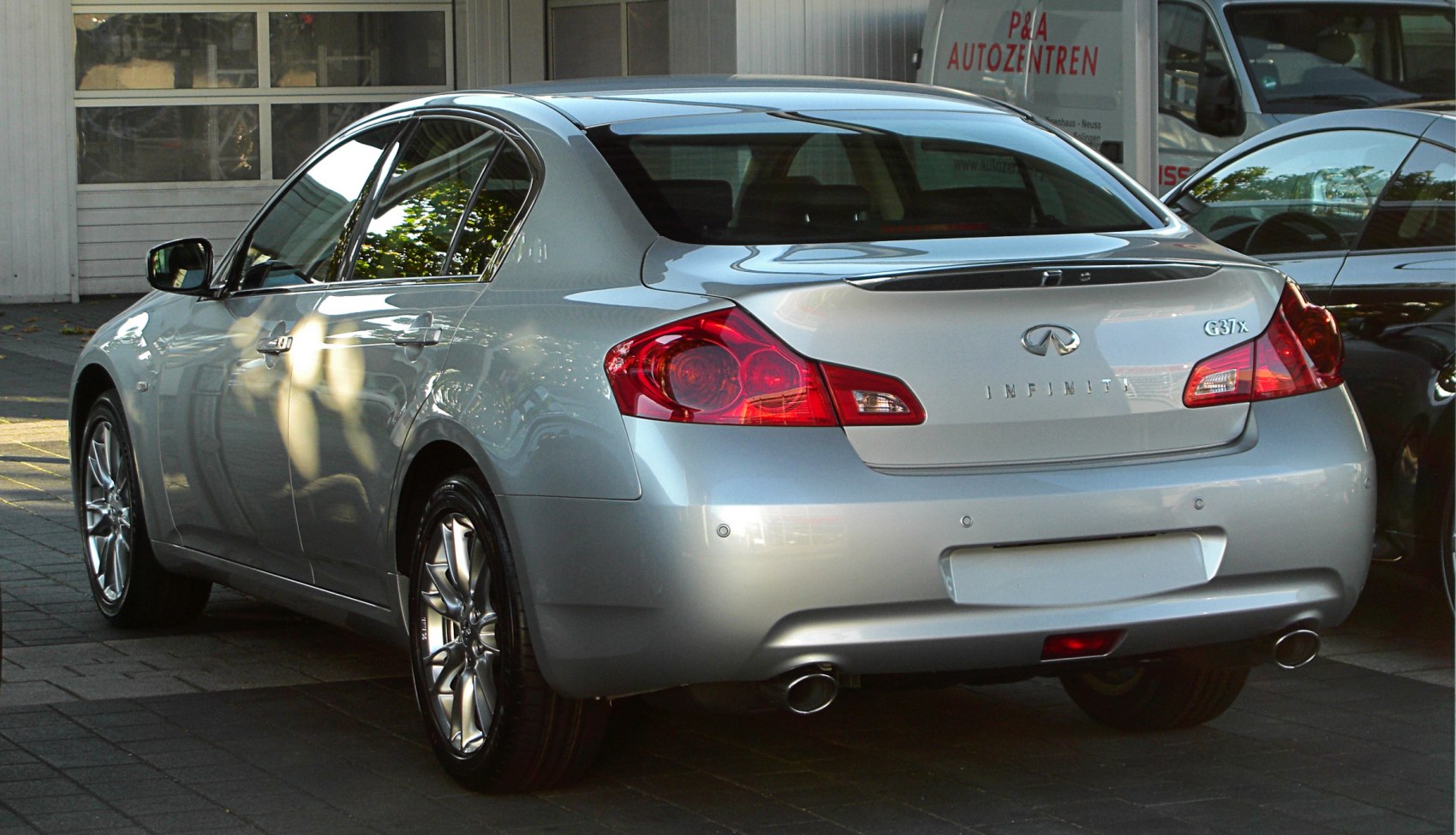 Rear view of silver sedan with dual exhaust and distinctive taillights