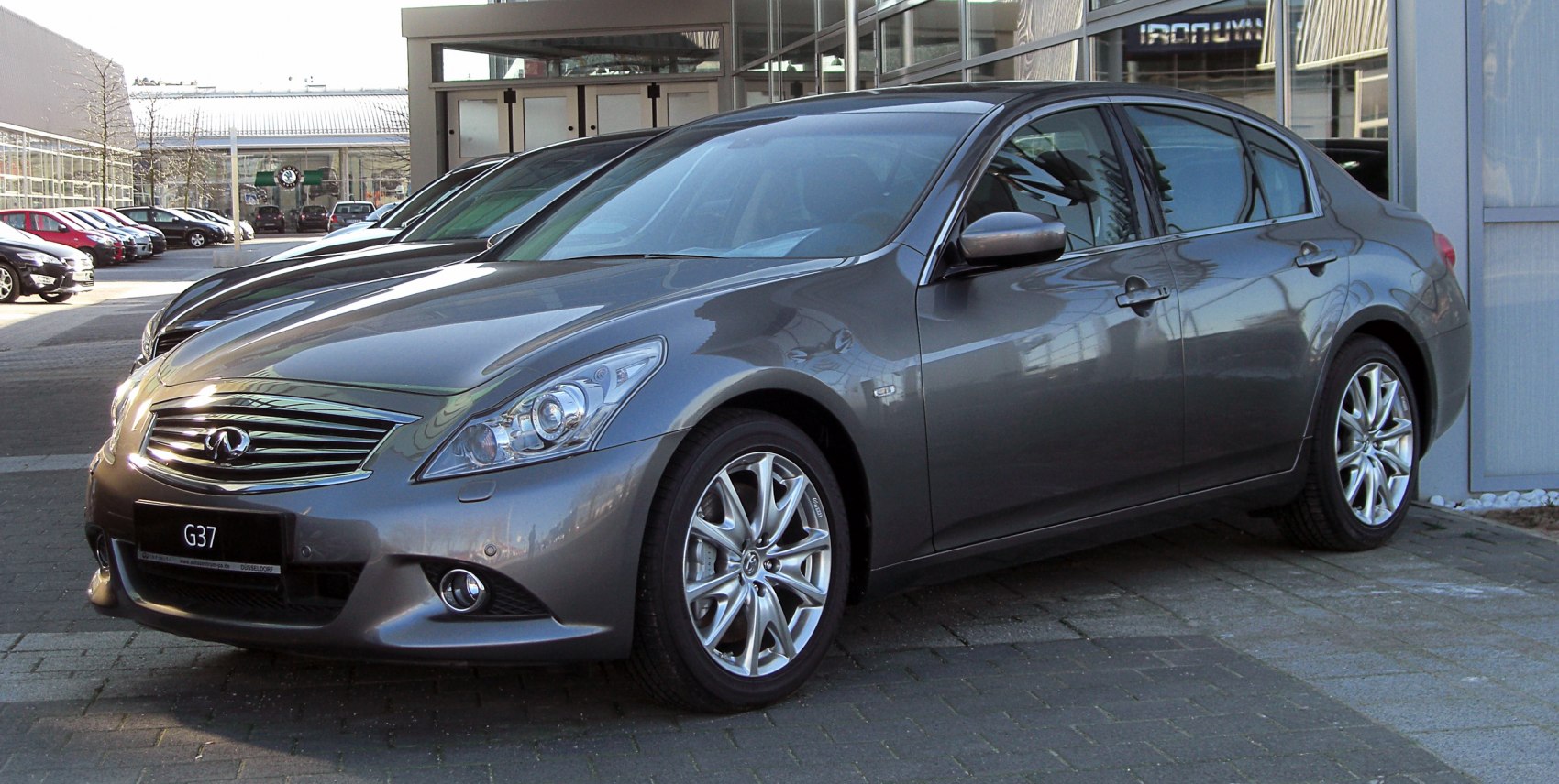 Front-side view of a sedan with distinctive grille and alloy wheels