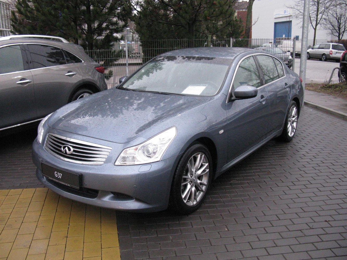 Sleek front-side view of a sedan with alloy wheels on wet pavement