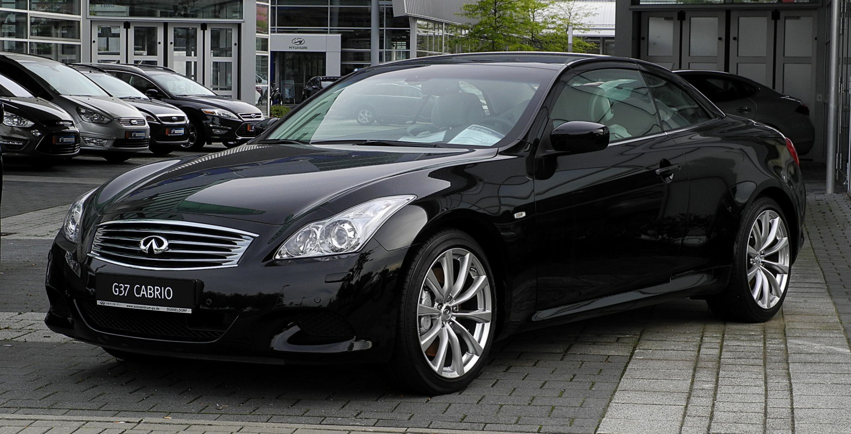 Sporty black convertible coupe with alloy wheels and sleek front grille