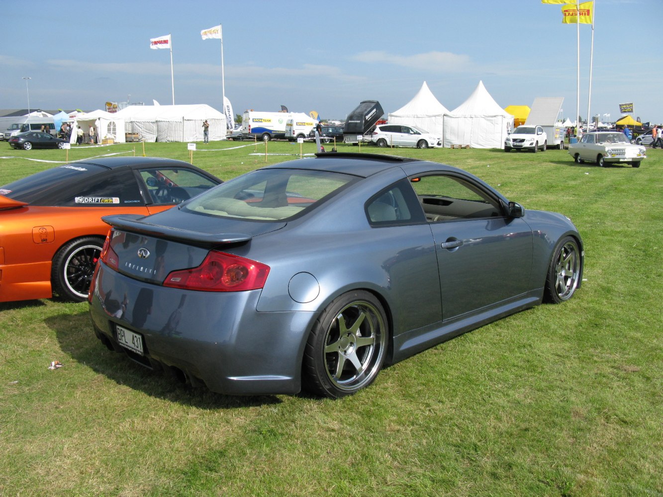 Coupe with rear spoiler, custom wheels, and lowered suspension