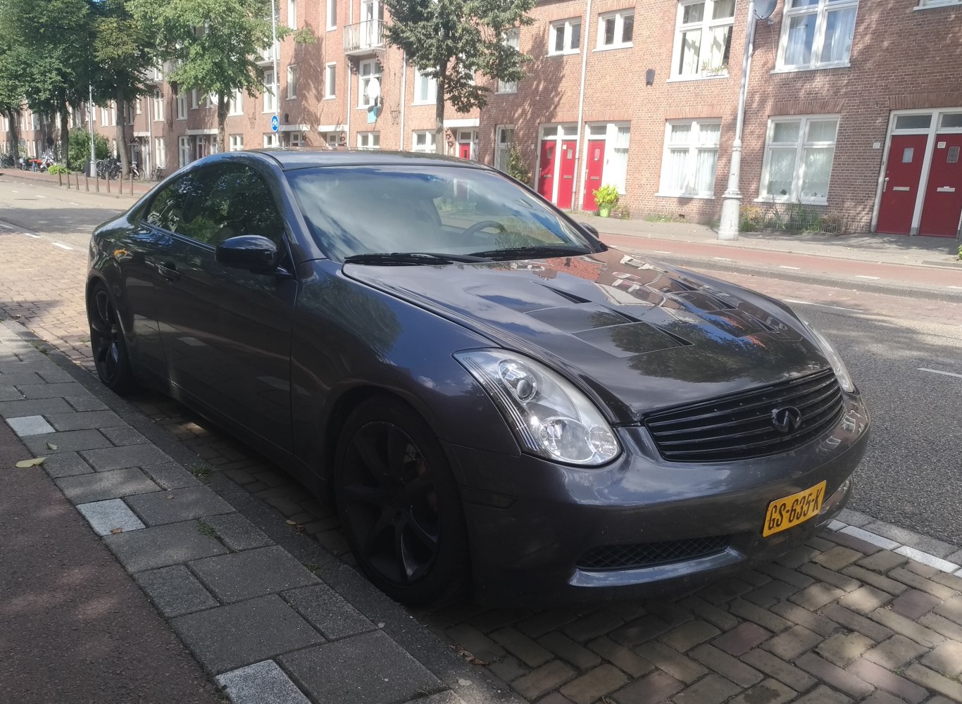 Sleek black coupe with black rims and aggressive hood vents
